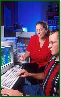 Image shows a computer and a person who is looking panicked.